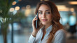 © ganlaya - a female business leader making a phone call in a corporate office
