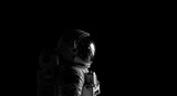 An astronaut exploring the vast, dark expanse of space against a starry black background