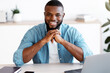 © Prostock-studio - Portrait of smiling african american entrepreneur sitting at desk in home office, handsome black male freelancer working on laptop computer, smiling at camera, enjoying distance job, free space