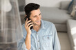 © fizkes - Phone call. Happy smiling millennial guy in casual wear speak on mobile telephone holding device close to ear chat with girlfriend sharing good news with friend enjoy pleasant conversation on weekend