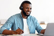 © Prostock-studio - Online Education. Smiling Black Guy In Headphones Study With Laptop And Taking Notes, Cheerful Millennial African American Man Using Computer And Writing Down Information, Enjoying Distance Learning