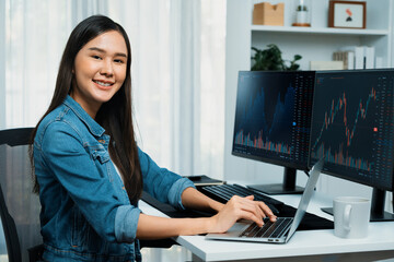 young asian in it developer looking at camera to present with online information on pc with coding p
