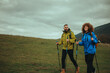 © Zamrznuti tonovi - Hikers walking up green hill on cloudy day
