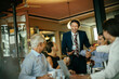 © Marko Geber - Group of business people having a meeting in a cafe bar
