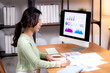 © NT_studio - Young asian businesswoman planning and strategy about finance looking graph and chart of report marketing in home office, business woman analyzing financial and revenue for success, business concept.