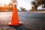Orange traffic cone on asphalt road during sunny day with blurred background Orange traffic cone on asphalt road during sunny day with blurred background