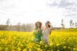 © maxbelchenko - Two young female friends having fun in a yellow rapeseed field, enjoying a walk. Beautiful women spending time together in a blooming field. Concept of friendship, fun and adventure.