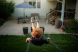 © Cavan Images - Young boy swinging high in backyard on summer evening