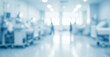 © al-sultan - Blurred hospital interior with beds and medical equipment in a bright sterile environment.
