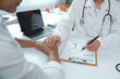 © crizzystudio - Doctor comforting patient and explaining diagnosis using charts and graphs