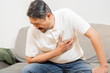 © Kunlathida - Side view shot of adult man having heartache at home. Heart disease.
