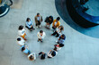© Jacob Lund - Overhead view of diverse group circle meeting in corporate setting