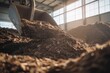 © antusher - Industrial compost being moved by shovel inside spacious composting facility