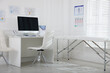 © New Africa - Doctor's workplace with modern computer and examination table in medical office