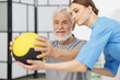 © New Africa - Doctor and patient exercising with medicine ball in clinic