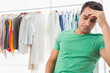 © Wavebreak Media - Male shopper pressing forehead while browsing pastel shirts on wooden hangers by window, copy space