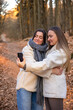© puhimec - Two friends taking a selfie on their phone in the forest. Friends in nature.
