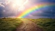 © Yuyun - A path through grassy hills leads to a vibrant rainbow, bathed in sunlight and dramatic clouds