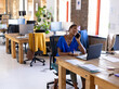 © Wavebreak Media - Adult African American woman using laptop at office desk, talking on smartphone, eating from bowl
