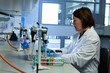 © Wavebreak Media - Female scientist operating pipettes at bench in lab with test tubes, laptop, gas hose, copy space