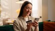 © Yuliia - Caucasian woman happy online shopping using mobile phone kissing bank credit card smiling at home satisfied girl female client success buying e-commerce purchase smartphone app order food delivery
