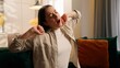 © Yuliia - Portrait sleepy tired exhausted yawning Caucasian woman girl female lady feeling fatigue sitting at couch problem health napping yawn at home in living room stretching hands relaxation lazy boring