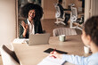 © Jelena - Businesswoman in Virtual Meeting Greeting a Colleague with a Smile