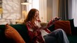 © Yuliia - Caucasian girl female woman happy falling on couch cozy home sitting on sofa rest chilling at living room eating popcorn watching TV film movie television relaxing weekend apartment insurance mortgage