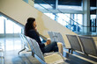 © Wavebreak Media - Business traveler sipping coffee and calling on phone while waiting on airport seats, copy space
