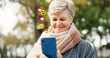 © CineLens2024/peopleimages.com - Elderly, happy woman or social media icons with phone in nature for online reaction or feedback. Senior, female person or user with smile on mobile smartphone for connection, communication or network