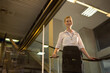 © Wavebreak Media - Female business traveler standing on down escalator in terminal holding roller suitcase, copy space