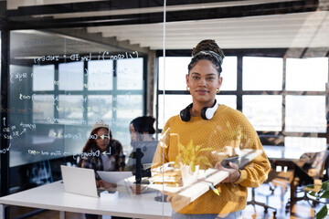 Confident woman coding on laptop in modern office