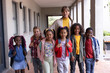 © Wavebreak Media - Smiling female teacher with diverse group of children wearing backpacks at school