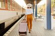 © Home-stock - Young woman traveler with suitcase walking on railway station platform, back view, full length. Travel, active lifestyle, summer vacation