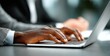 © oksa_studio - Close up of hands typing on laptop keyboard during an office meeting, showcasing teamwork and collaboration in a professional setting