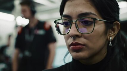 Focused programmer intently analyses motorsport statistics on her desktop station