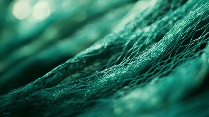 Close-up of teal fishing net texture, showing intricate weave and details.
