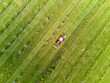 © Cavan Images - Tractor mowing green grass field on a sunny day