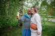 © Cavan Images - Two ethnically diverse women taking a selfie in a lush green park