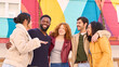 © Oscar - Group of multiethnic young people smiling and having fun in front of colorful wall