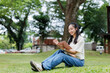 © Phimwilai - Young student studying in park enjoying academic pursuit
