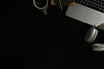 Wall Mural - flat lay of stylish black desk with laptop, notebook, pen, and wireless headphones