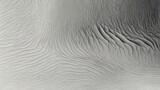 Aerial view of textured gray surface with wavy patterns and subtle shadows creating depth and dimension