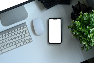 Wall Mural - flat lay of mobile phone, keyboard, and mouse next to green plant on desk