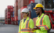 © Nassorn - Industrial engineer standing at shipping container yard inspecting cargo delivering loading as plan. Cargo manager and diverse ethnic worker checking import export container at logistic terminal dock.