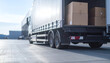 © PoodPhoto - A close-up of a delivery truck loading boxes in a warehouse environment, showcasing logistics and transportation.