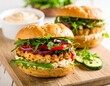 © Simon - Delicious homemade chicken burgers with fresh arugula and veggies on a wooden board
