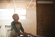© WavebreakMediaMicro - Senior woman shaping clay on pottery wheel in lit workshop wearing apron with window and lamp