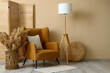 © Pixel-Shot - Interior of stylish living room with brown armchair, standard lamp and pampas grass