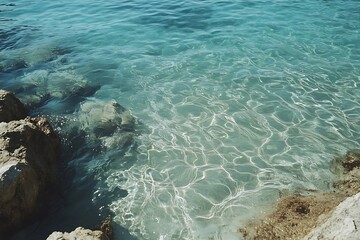 Wall Mural - early sunlight glimmering across shallow sea water, delicate wavelets casting dancing reflections